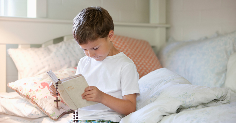 A boy maintaining a Bible sooner than faculty.